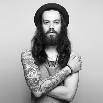 tattooed handsome bearded man in hat