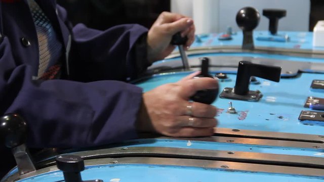 Female hands control the levers of lifting mechanics at the mine\The arms control levers