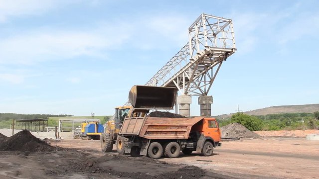 truck with coal\bulldozer loads coal into a lorry