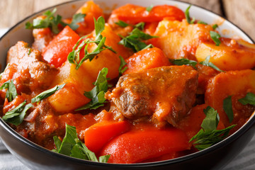 Filipino beef stew mechado with potatoes, peppers, carrots and onions close up in a bowl. horizontal