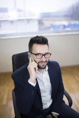 Young business man with glasses talking on phone