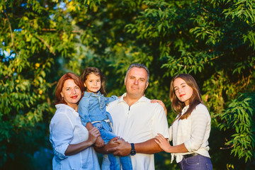 happy family of four people in the woods on a walk