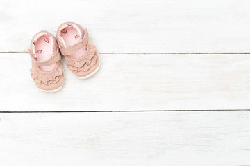 Pink shoes for little girl on a white wooden background. Copy space