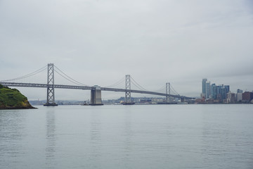 Fototapeta na wymiar The beautiful skyline of San Francisco with the Oakland Bay Bridge in a cloudy day