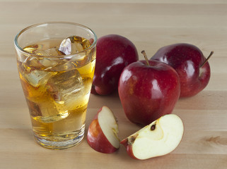 A Glass of Fresh Cold Apple Juice with Ice Beside Apples on A Wooden Table