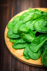 Fresh juicy spinach leaves on a wooden brown table. Natural products, greens, healthy food, vitamins.