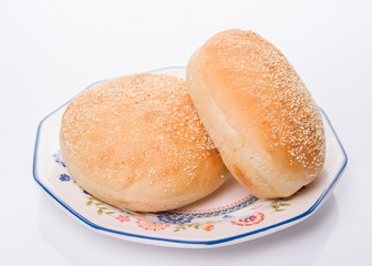 Sesame bread buns in earthenware dish, isolated on white background