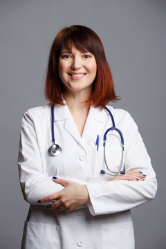 Image of smiling female doctor in white coat and with phonendoscope