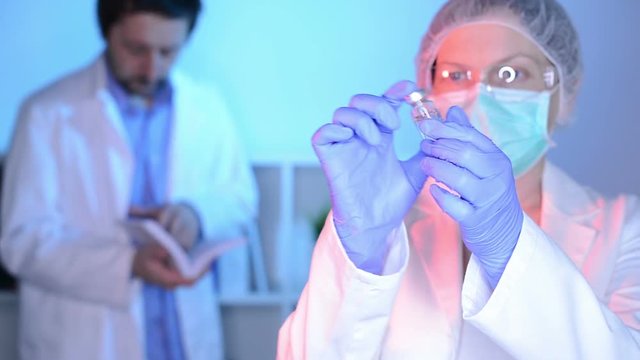 Doctor and nurse analyzing unknown MMR vaccine in medical clinic hospital