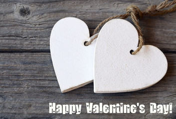 Happy Valentine's Day.Decorative white wooden hearts on rustic wooden background.St Valentine's Day or Love concept.Selective focus.
