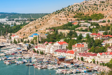 Aerial view of Old Town port, sea and mountains. Yachts and boats moored at the pier. Balaklava, Sevastopol, Crimea