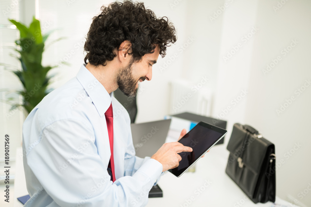 Wall mural Businessman using a tablet