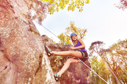 Young woman abseiling training on steep rock
