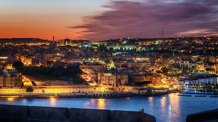 Fototapeta na wymiar Malta: Il-Gzira and Marsans Harbour. Aerial view from city walls of Valletta at sunset