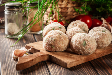 Obraz na płótnie Canvas Raw meatballs rolled in a crispy bun prepared for baking