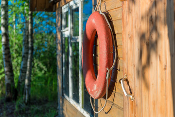 old lifebuoy close-up on a wooden wall of a rural house near a lake