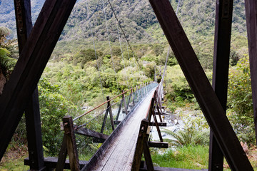 Fototapeta na wymiar New Zealand Fox Glacier old historic wooden swing bridge