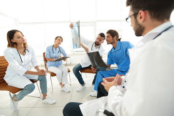 radiologists and a surgeon discussing a radiograph of a patient