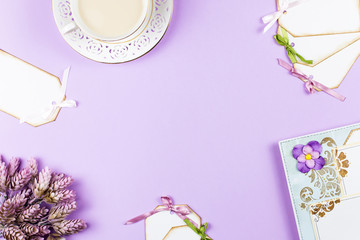 Fototapeta na wymiar Scrapbook background with decoration, tea cup, flowers on purple background, copy space.