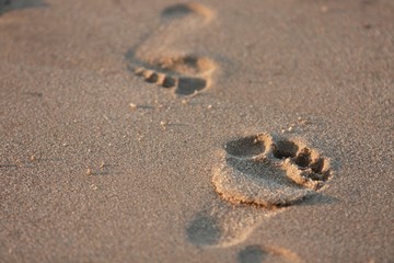 zwei sich begegnende Fußspuren im Sand