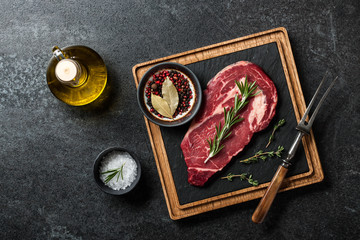 Raw beef steak, spices and fork