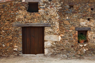 Facade of old house with windows and wooden door.