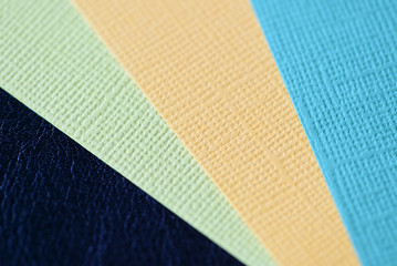 Fototapeta premium Colorful cardboads on a dark leather background close up