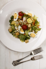 salad dish with croutons, cherry tomatoes, boiled egg quarters and dried parsley