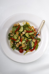 cucumber salad with croutons and red bell pepper stripes on a plate