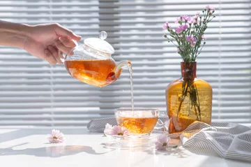 Crédence de cuisine en verre imprimé Theé Tea being poured into glass teacup in the morning.