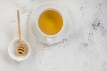 Tea and honey stick top view on a white background, copy space