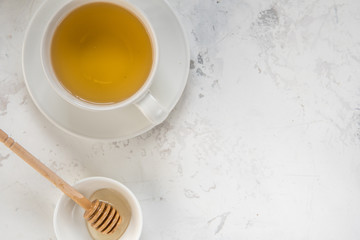 Fototapeta na wymiar Tea and honey stick top view on a white background, copy space