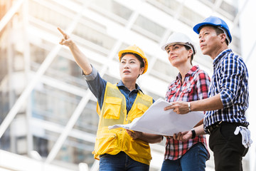 Engineers man and woman working on plan building construction in city