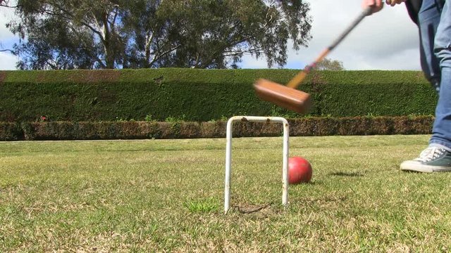 A low shot of players playing croquet