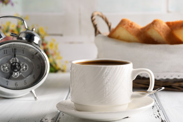 Start up concept.Coffe cup,alarm clock and toast in the basket. Morning coffee day start.