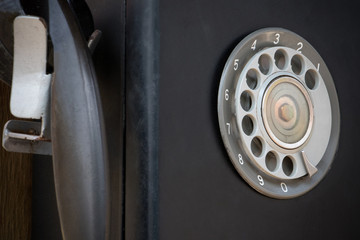 Closeup of black retro vintage telephone with rotary dialer or dialpad. Local vintage telephone for background with copyspace.