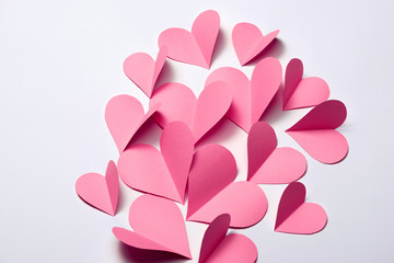 Beautiful pink paper hearts on white paper background
