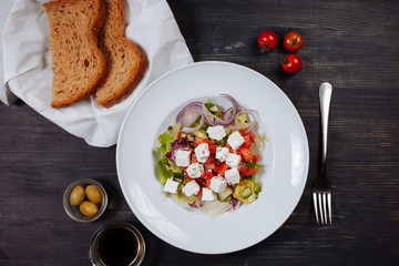 Top view of tasty greek salad with bread