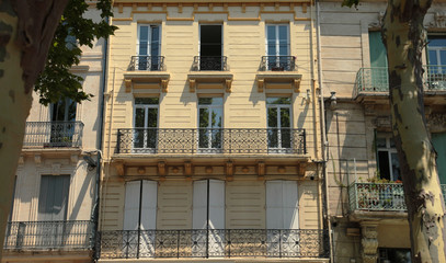 Fototapeta na wymiar Stylish cross section of apartment balconies, sunny day in a small village square in the South of France