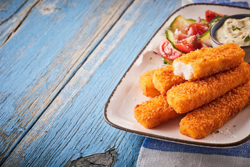 Tasty oven baked fish fingers with salad