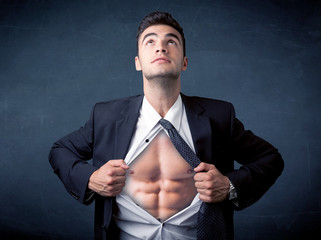 Businessman tearing off shirt and showing mucular body