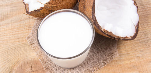 Coconut with coconut milk on wooden background.