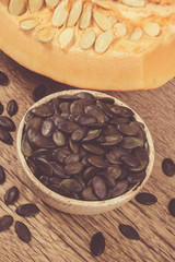 Pumpkin seeds on a wooden background.