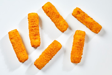 Fried fish fingers against white background