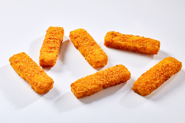 Crispy fish fingers against white background