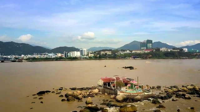 Buddhist Temple on Rocky Island at Sea by Resort City