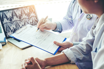 Doctor consulting with patient presenting results on x-ray film About the problem of the patient
