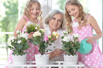 granny with granddaughters watering flowers