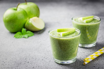 Green apple smoothie on concrete background. Selective focus, space for text. 