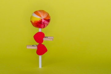 red heart attached to a stick candy, a clothespin, and it's like a man in love